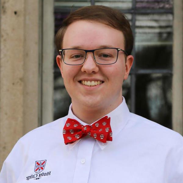 a young man with glasses and a Rhodes bowtie